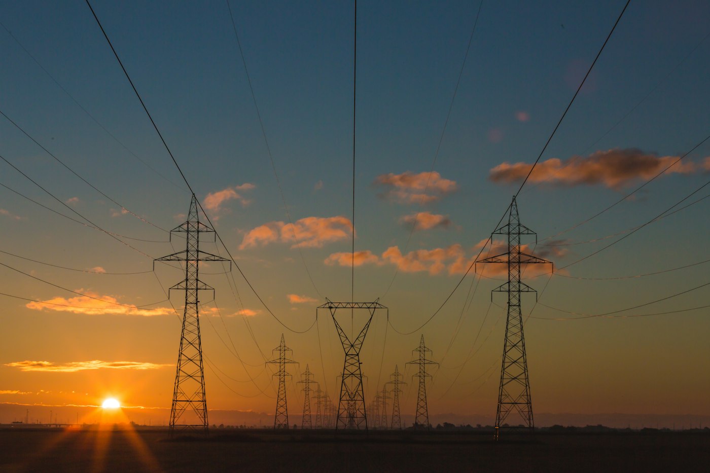 High-voltage power lines against a sunset sky